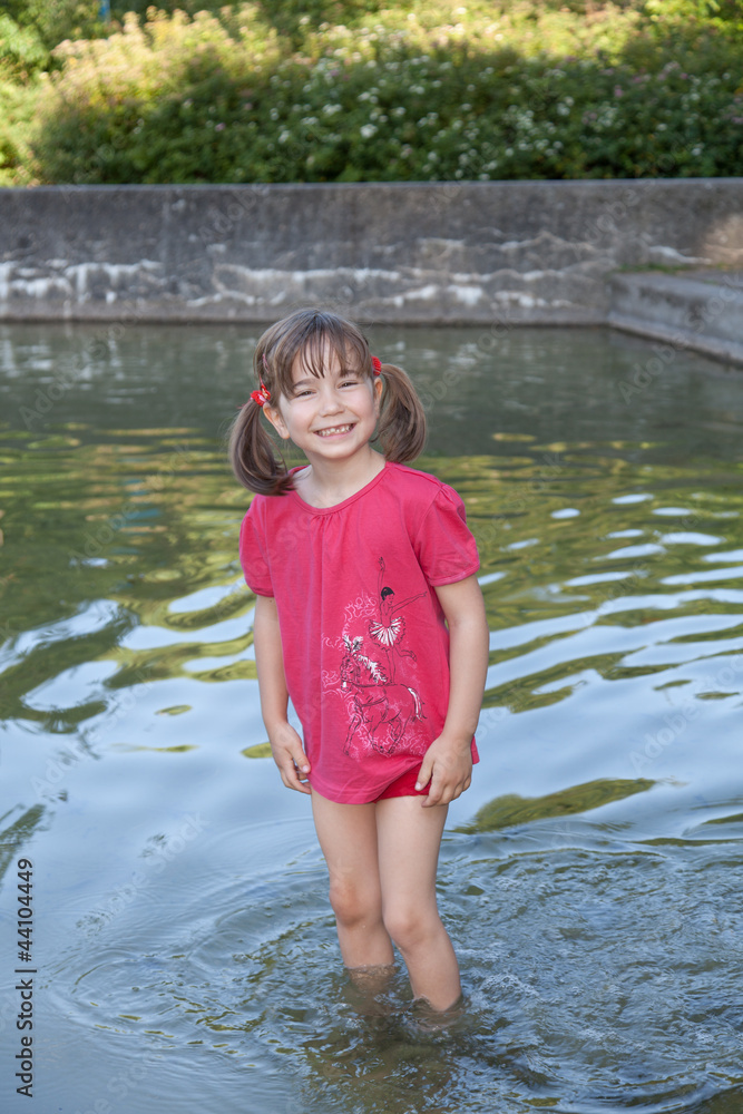 Das kleine Mädchen spielt im Wasser StockFoto Adobe Stock