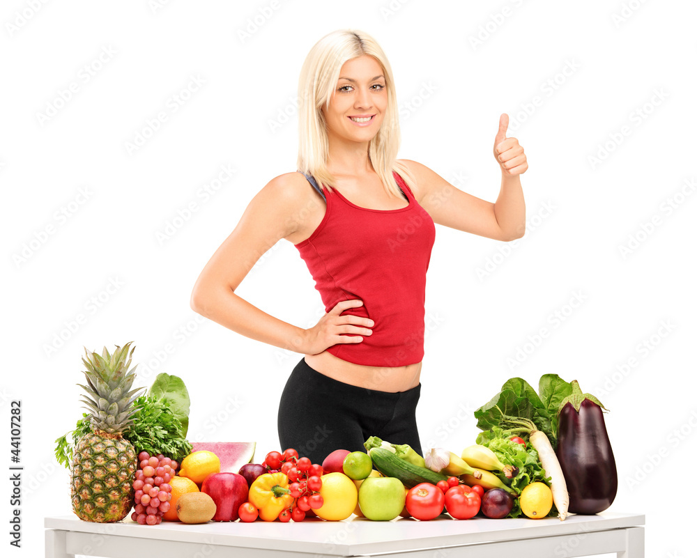 Healthy smiling woman with fruits and vegetables giving a thumb Healthy smiling woman with fruits and vegetables giving a thumb