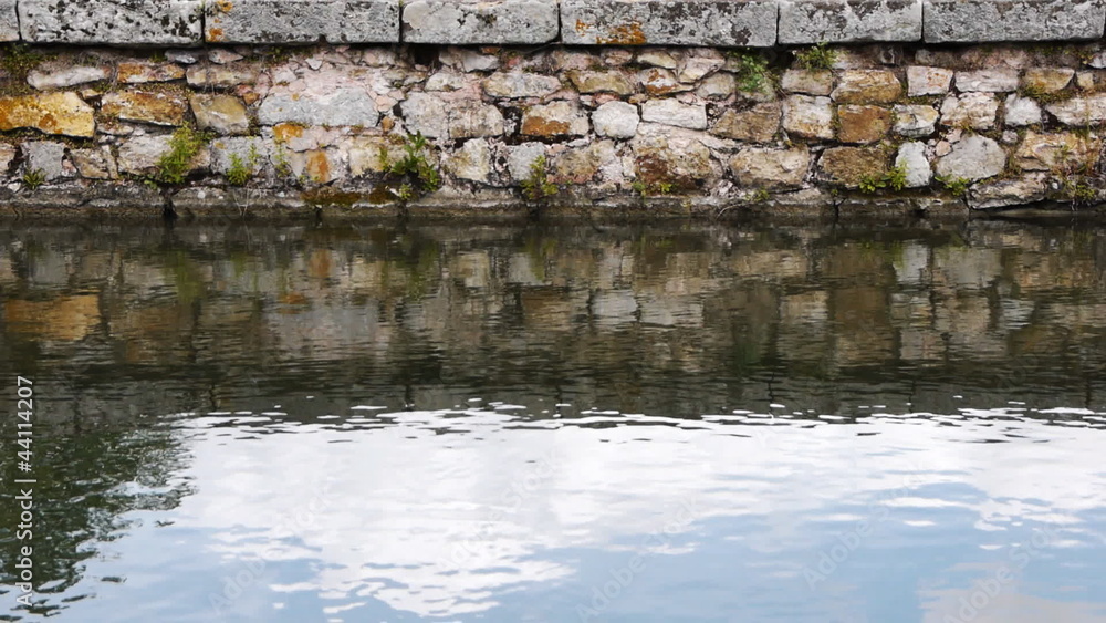 Water in front of an old brick wall Water in front of an old brick wall