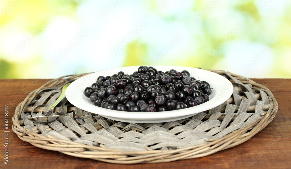 Fresh blueberries in plate on green background Fresh blueberries in plate on green background