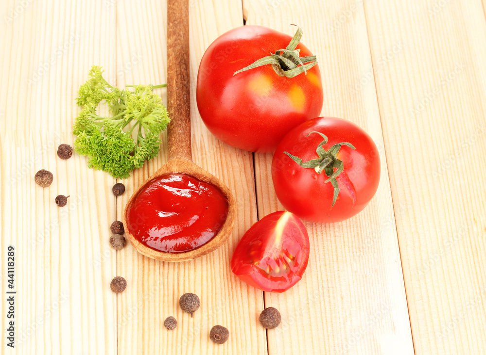 Ketchup and ripe tomatoes on wooden table Ketchup and ripe tomatoes on wooden table