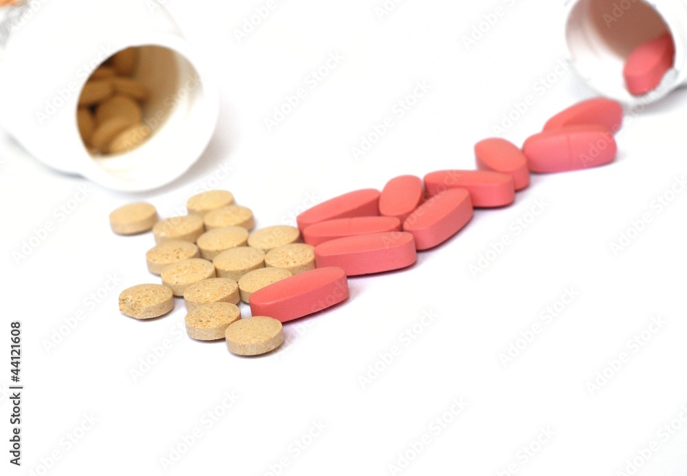 Pills pouring out of the white bottle