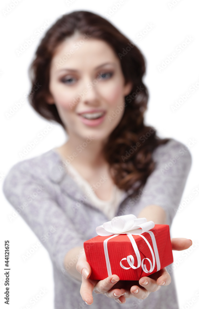 Young woman offers a present wrapped in red paper Young woman offers a present wrapped in red paper