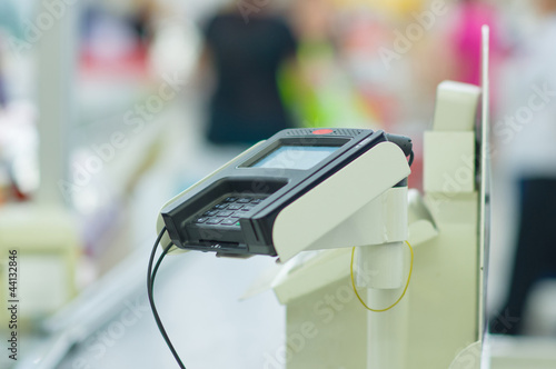 Credit card reader terminal on cash-desk in supermarket