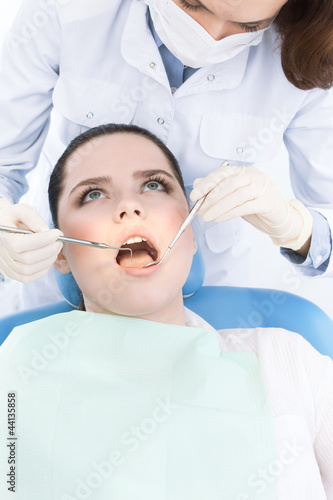 Dentist's assistant checks the teeth of the patient