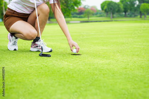 Close up of female golf player picking up ball