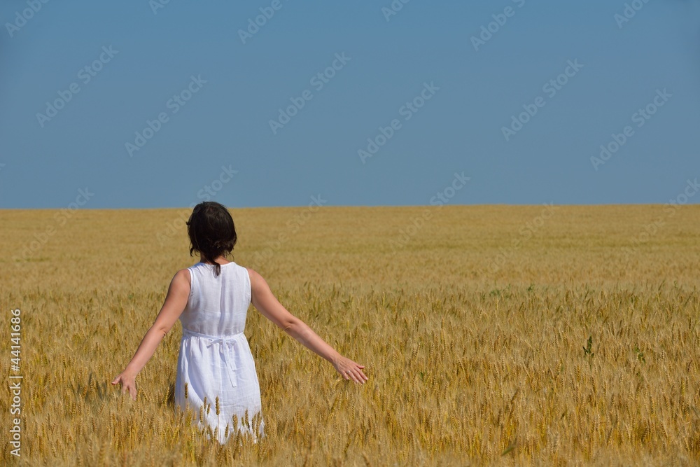 young woman in wheat field at summer