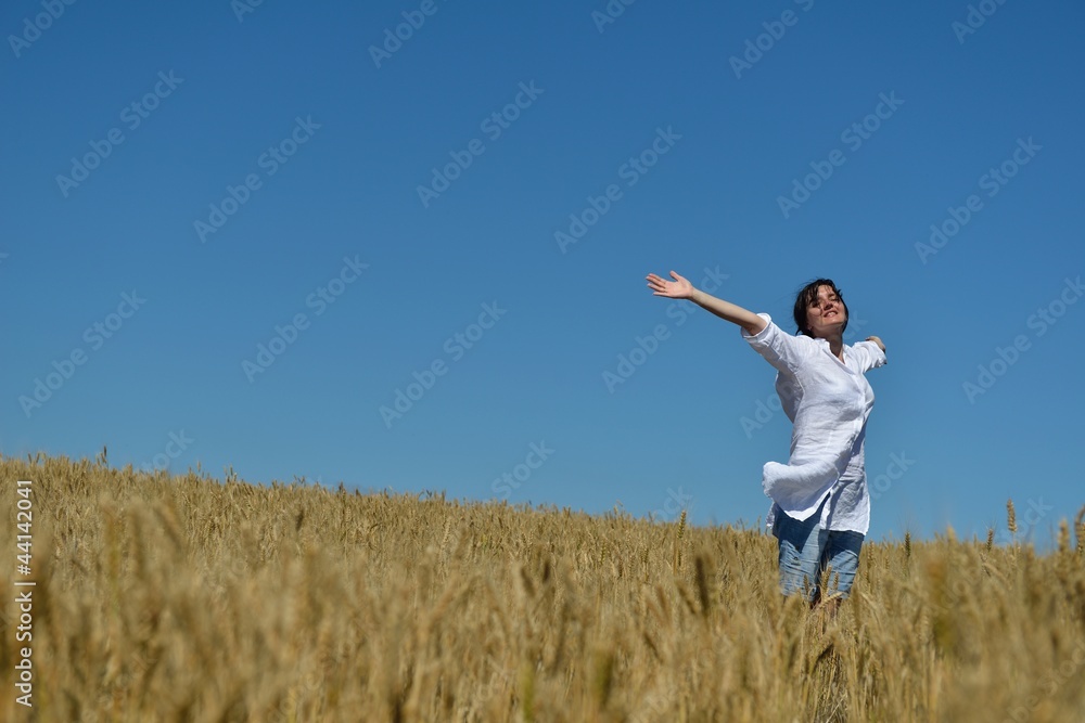 young woman in wheat field at summer