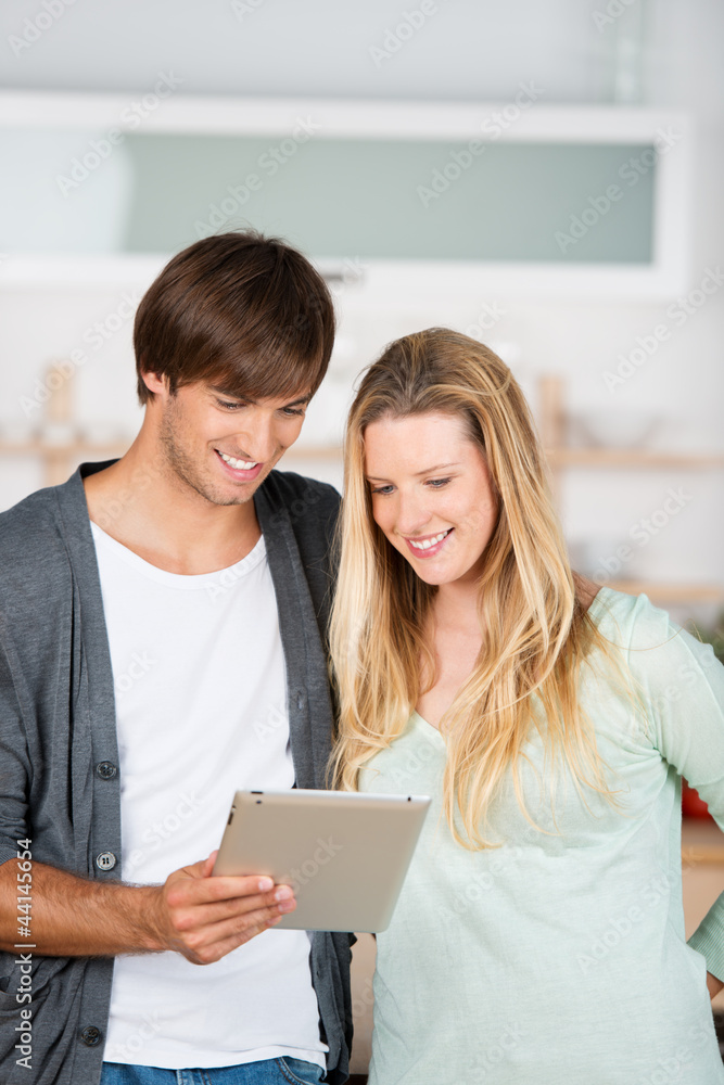 paar in der küche schaut auf tablet paar in der küche schaut auf tablet