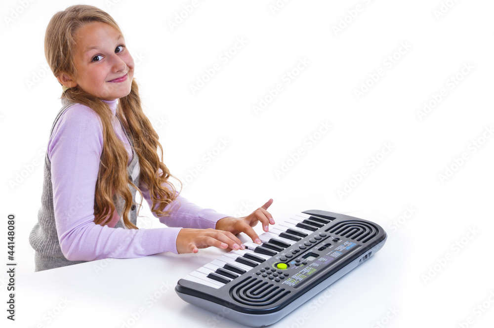 Schoolgirl playing on a small synthesizer Schoolgirl playing on a small synthesizer