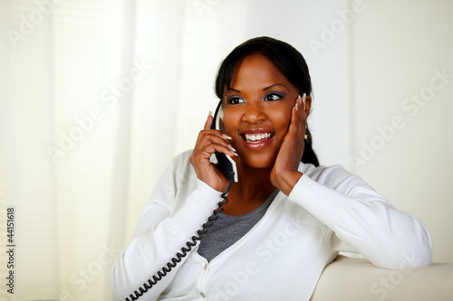 Surprised female smiling and conversing on phone