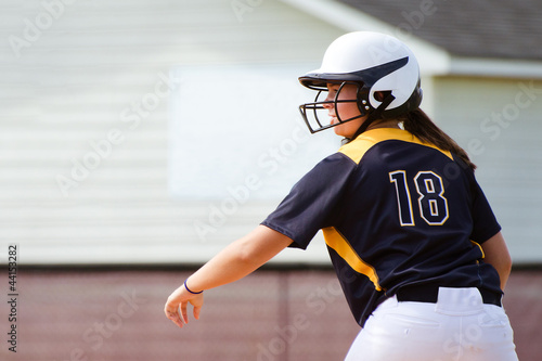Young teen girl playing softball in organized game photo