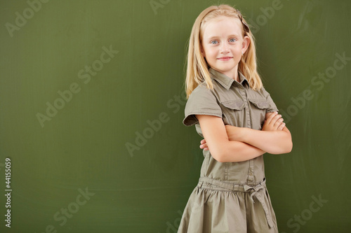 Scoolgirl standing near blackboard © Sergey Nivens