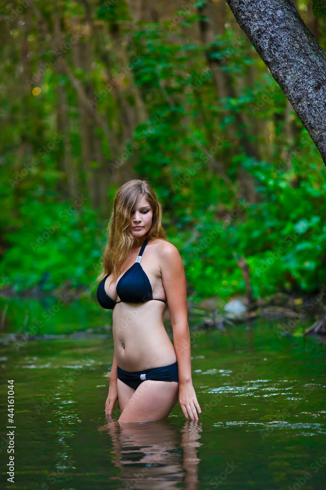 Foto de blonde young woman with large breasts in black bikini