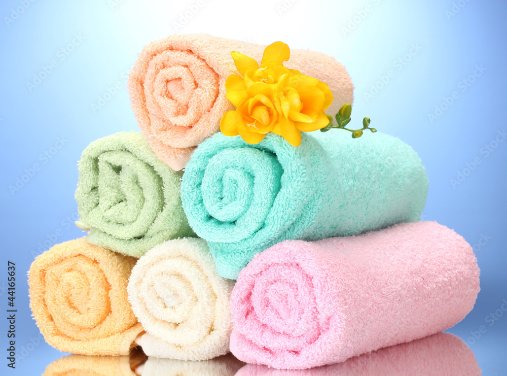 colorful towels and flowers on blue background colorful towels and flowers on blue background