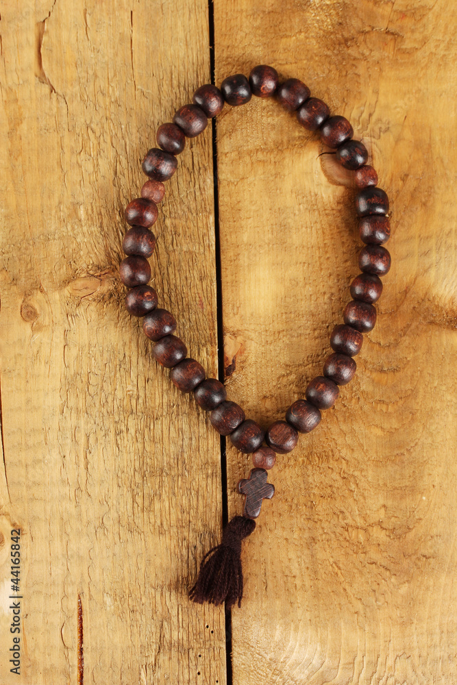 the Wooden rosary beads on wooden background close-up the Wooden rosary beads on wooden background close-up