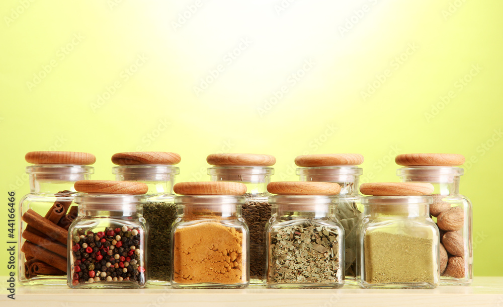 powder spices in glass jars on green background powder spices in glass jars on green background