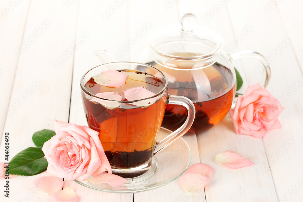 teapot and cup of tea with roses on white wooden table teapot and cup of tea with roses on white wooden table