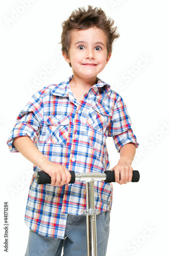 Naughty hairy little boy in shorts and shirt with scooter