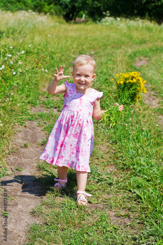 A little girl walks by the field A little girl walks by the field