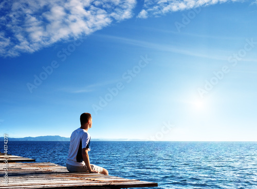 young man relax siting on pier