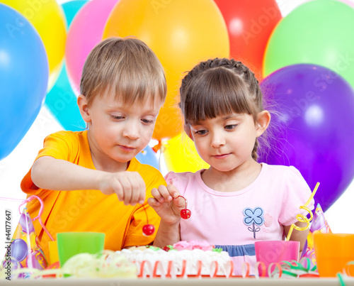 kids boy and girl eating cake on party birthday