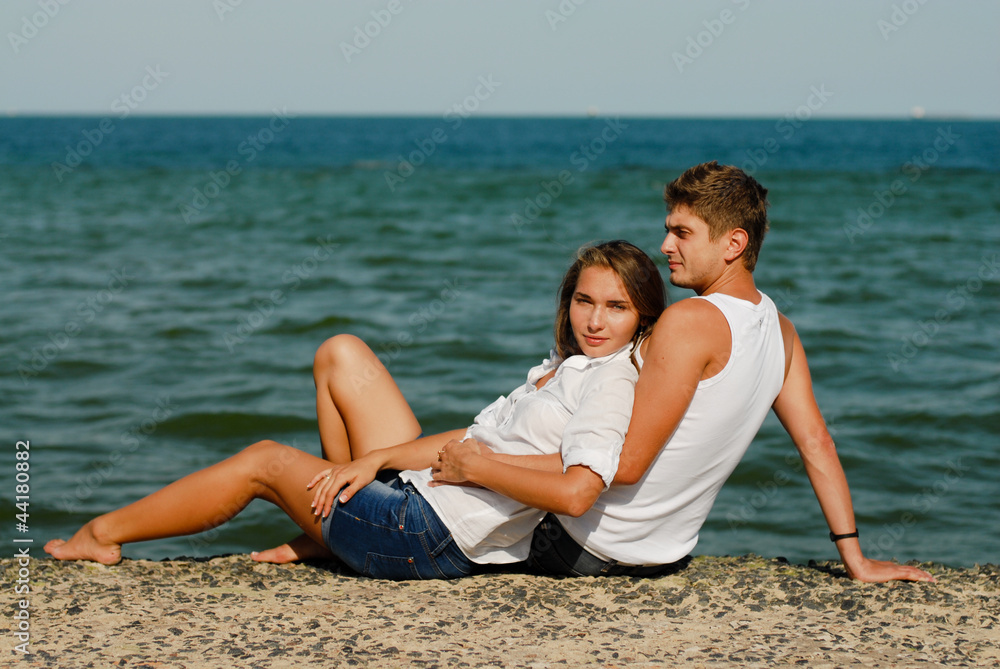 Happy young couple by blue sea over blue sky background