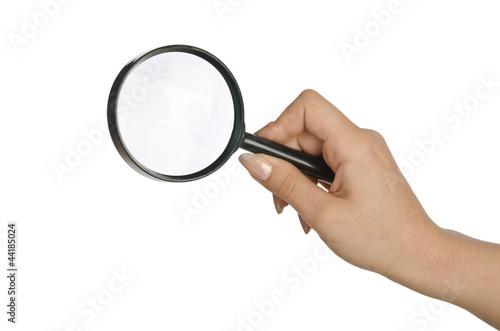 Hand holding magnifying glass on white