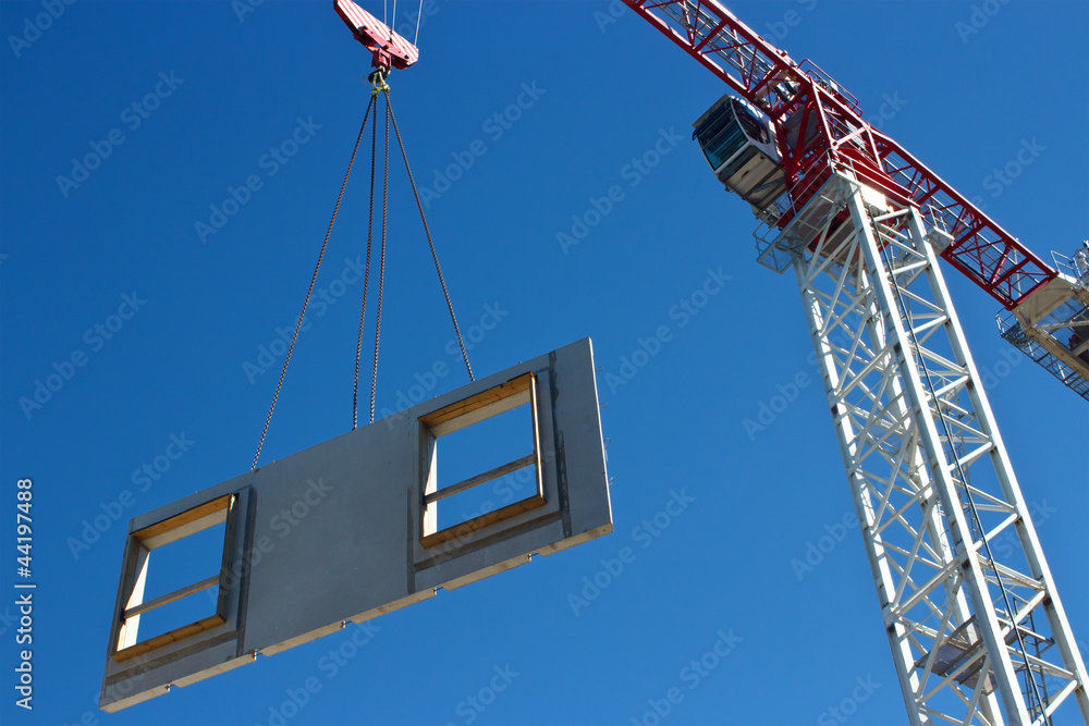 Tower crane is lifting preacast concrete panel