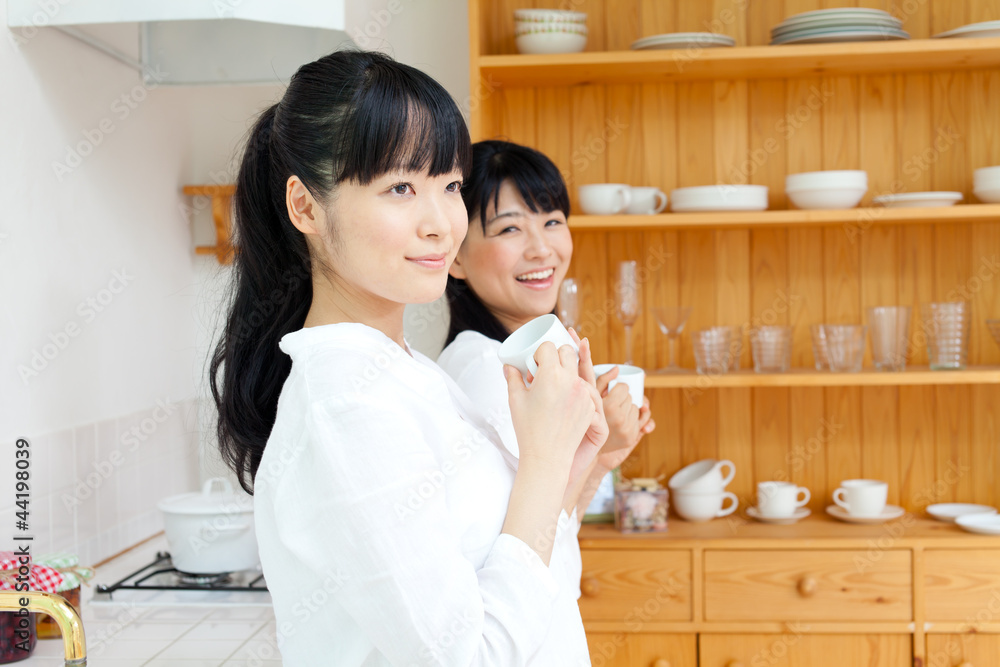 Beautiful young women relaxing in the kitchen. Portrait of asian Beautiful young women relaxing in the kitchen. Portrait of asian
