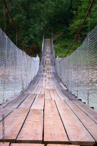 Fototapeta Naklejka Na Ścianę i Meble -  Suspension bridge across mountain river