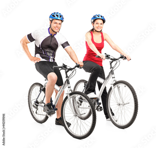 Full length portraits of young male and female bikers on a bike