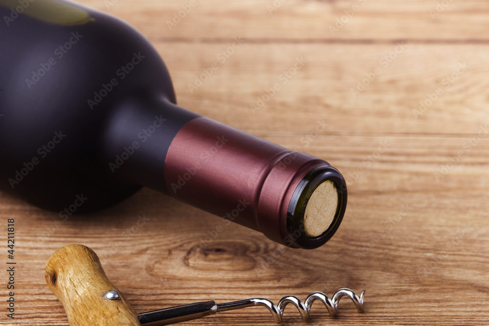 corkscrew and bottle of wine on the board