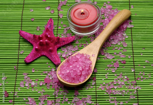 Red bath salt in wooden spoon with starfishand candle photo