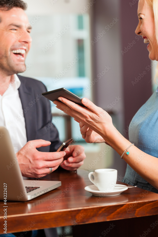 Working colleagues - man and woman - sitting in cafe Working colleagues - man and woman - sitting in cafe