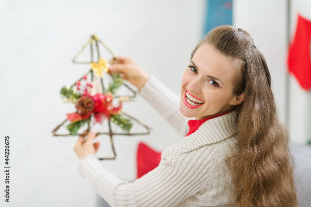 Smiling woman holding Christmas decoration tree Smiling woman holding Christmas decoration tree