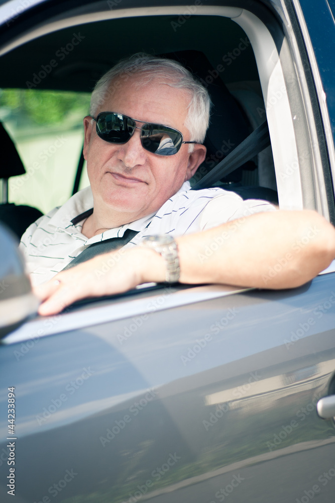 Naklejka premium Handsome middle-aged man driving a modern car