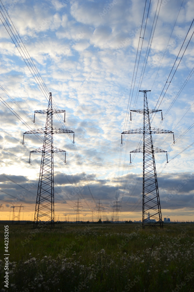 Electrical transmission towers at cloudy sunset