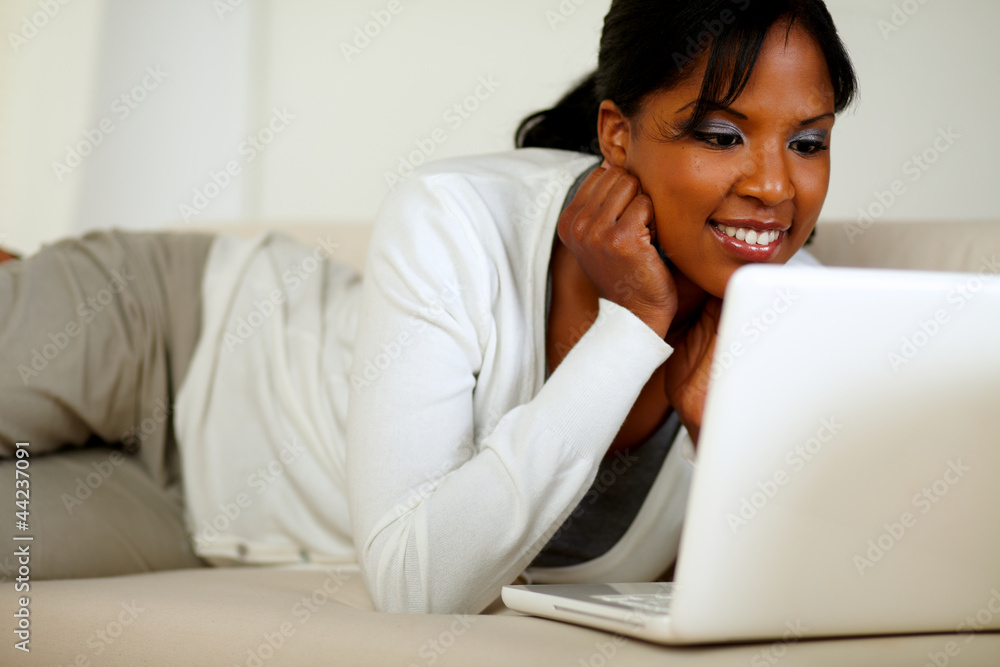 Afro-american young woman reading on laptop screen Afro-american young woman reading on laptop screen