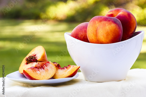 Sliced peach and bowl full of peaches