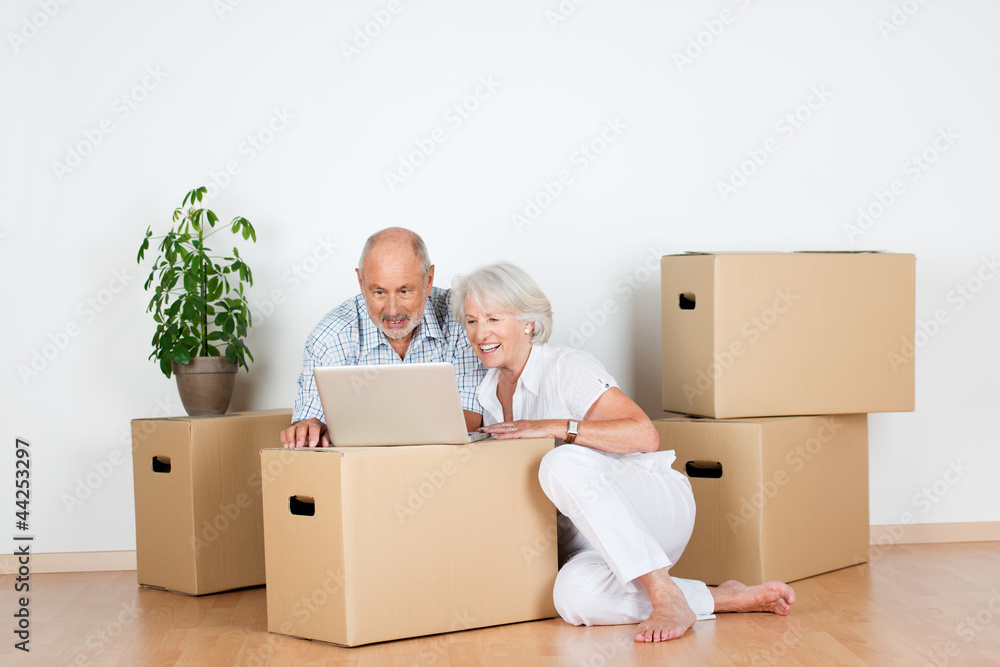 senioren-ehepaar organisiert umzug am laptop Stock-Foto | Adobe Stock