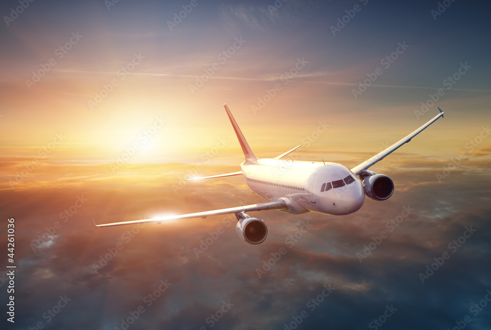 Naklejka premium Samolot na niebie o zachodzie słońca