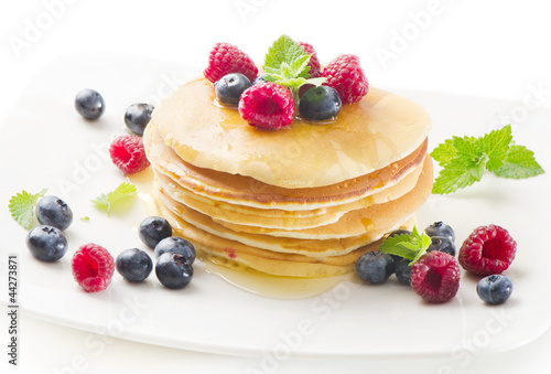 pancakes with raspberries and blueberries isolated on white