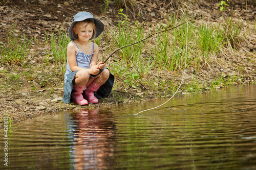 Fototapeta Naklejka Na Ścianę i Meble -  Little girl are fishing on lake in forest