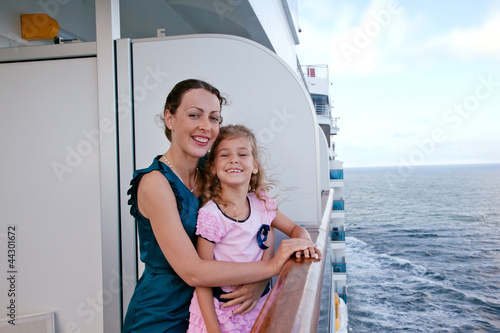 smiling mother and daughter traveling on big cruise ship