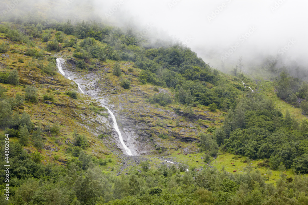 Waterfalls in misty mountains.