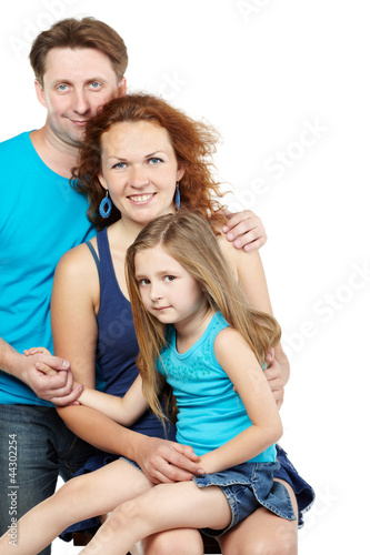 Family of three, father stands behind sitting mother