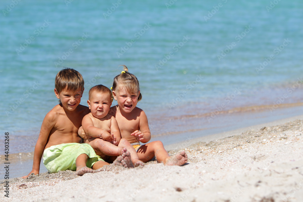 three happy children on sea background