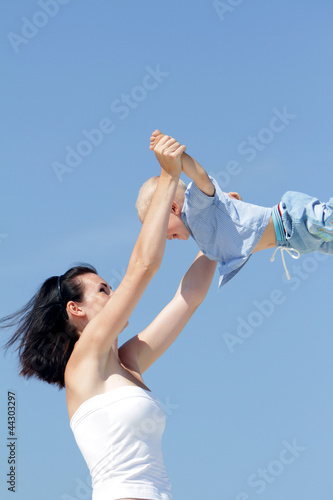 outdoor portrait of young mother playing with child isolated on