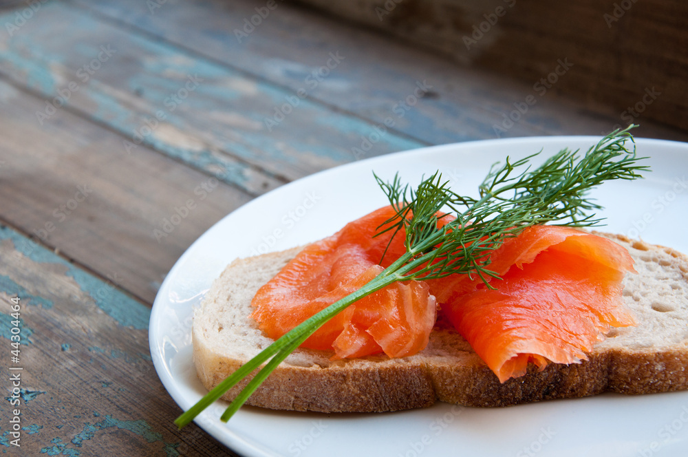 Smoked salmon on sourdough bread garnished with fresh dill. Smoked salmon on sourdough bread garnished with fresh dill.